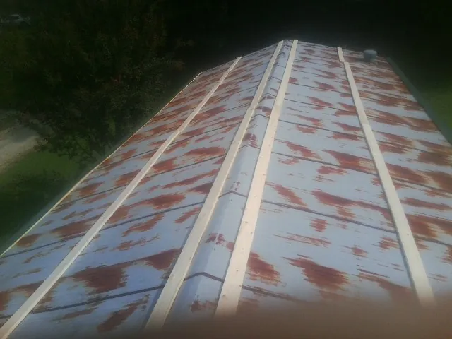 Rusted metal roof panels with new wood purlins before replacement — Storm Damage Roof Repair in Sunset Beach by Roofing Brothers
